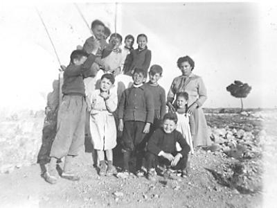 bonet0005  A L'ERMITA  EL 8-3-56.  LA DONA DE LA DRETA ES LA CARME RIBELLES PAU, ABAIX SENTAT EL BEP BONET "MARIANA", EL QUE PORTA EL BRAÇ ENLAIRE NO HO SÉ, L'ALTRE EL JOSEP Mº BONET, JOSEP REBULL "JAN", DEONISIO COSTAFREDA I LISA REBULL. ELS DE DALT: NOMÉS LA ROSITA SARDÀ.